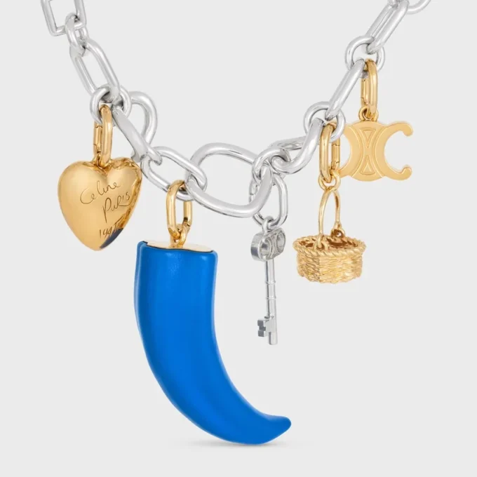 Dije pequeño en forma de cuerno de resina, cuero y latón con acabado dorado Dije pequeño en forma de cuerno de resina, cuero y latón con acabado dorado